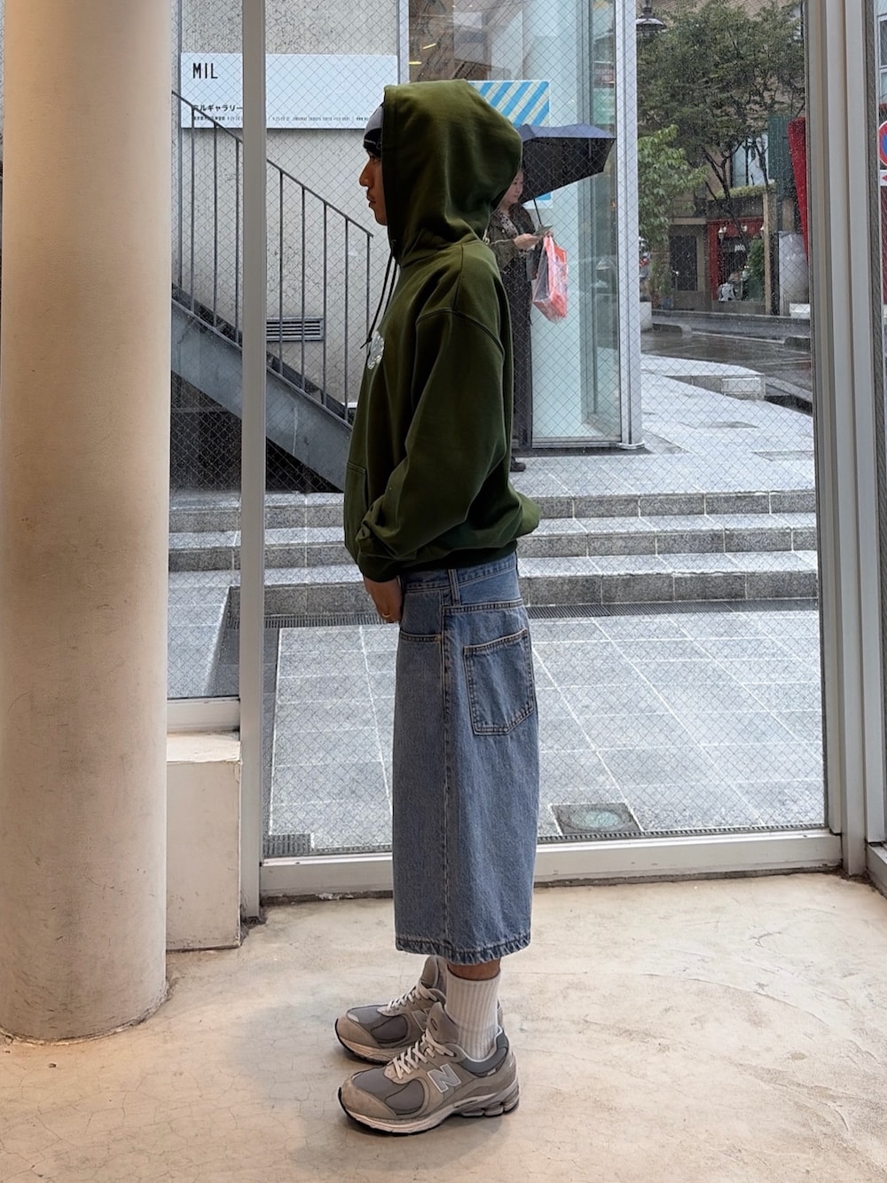 グリーン系のパーカー、グリーン系のデニムパンツ、ブルー系のキャップを着用したメンズの秋コーディネートの2枚目の写真