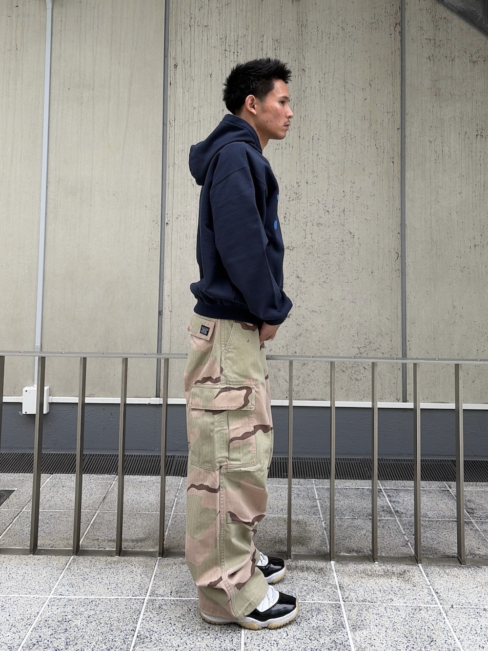 ピンク系のパーカー、グリーン系のカーゴパンツを着用したメンズの春コーディネートの3枚目の写真
