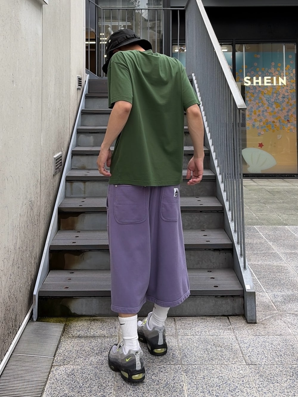 ブラック系のTシャツ/カットソー、グレー系のスウェットパンツ、ブラック系のハットを着用したメンズの夏コーディネートの4枚目の写真