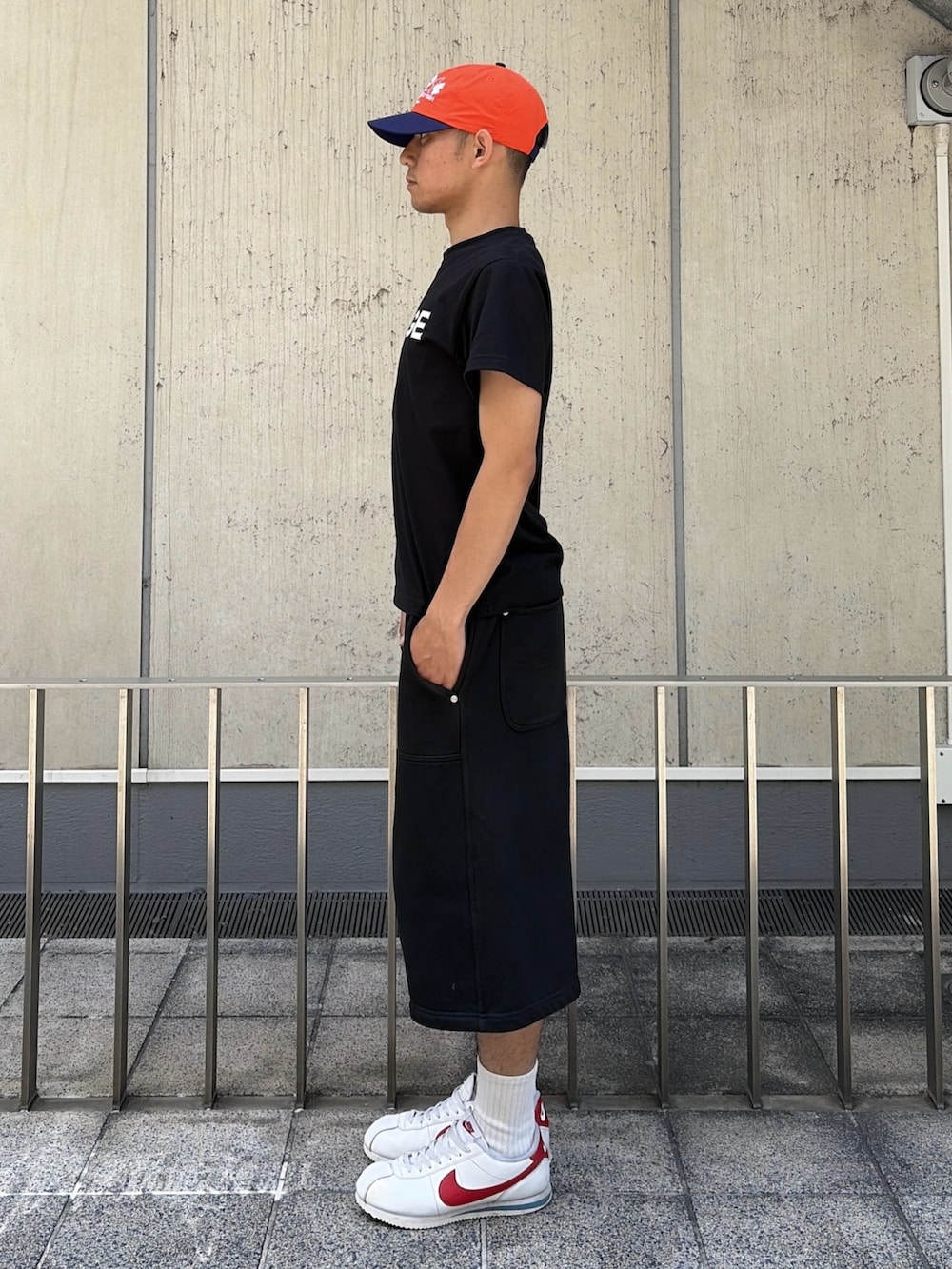 ピンク系のTシャツ/カットソー、グレー系のスウェットパンツ、オレンジ系のキャップを着用したメンズの夏コーディネートの2枚目の写真