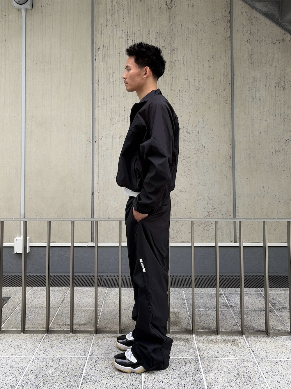 ブラック系のナイロンジャケット、ブラック系のその他パンツを着用したメンズの春コーディネートの2枚目の写真