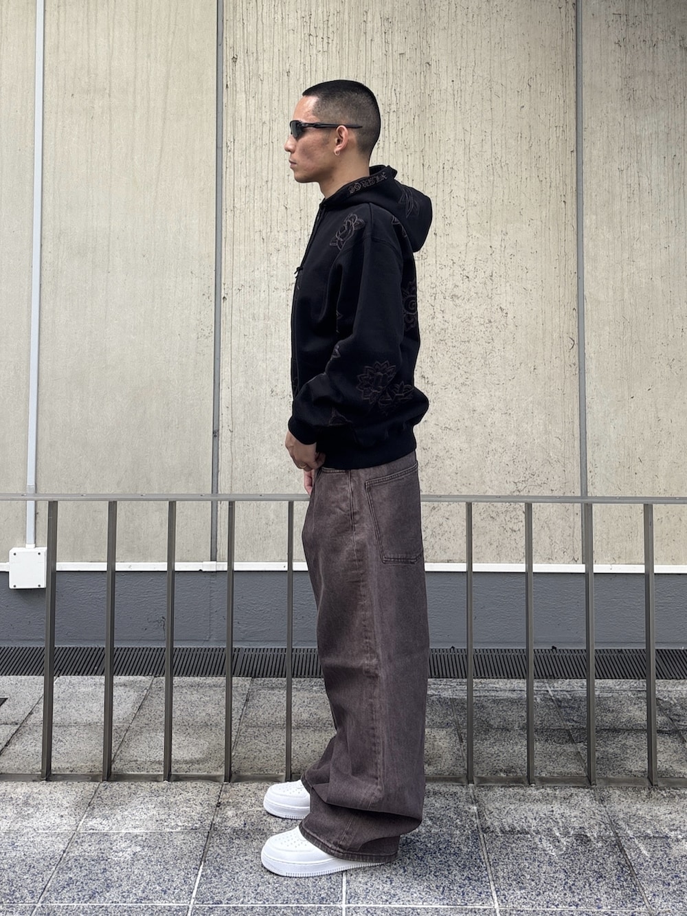 ブラック系のパーカー、ブラウン系のデニムパンツを着用したメンズの冬コーディネートの4枚目の写真