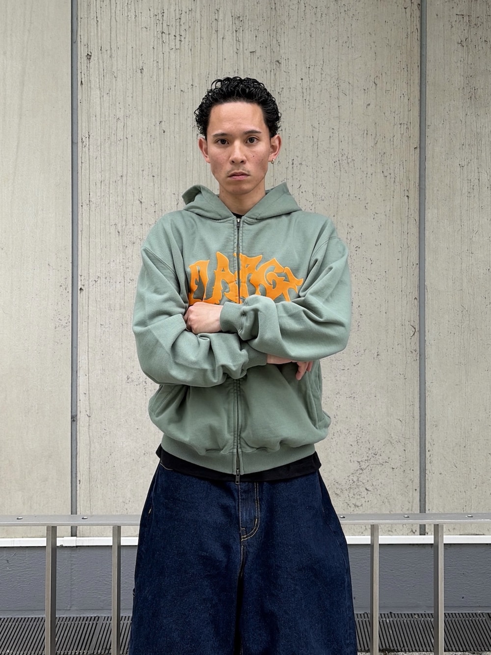 ピンク系のパーカー、ブルー系のデニムパンツを着用したメンズの春コーディネートの5枚目の写真