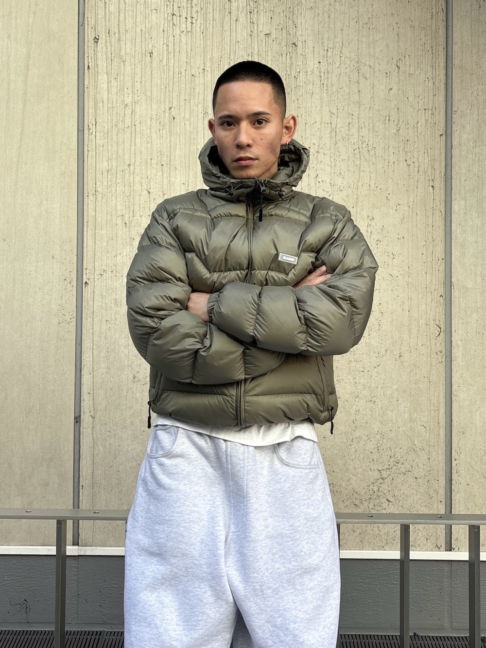 グリーン系のダウンジャケット/コート、グレー系のスウェットパンツを着用したメンズの冬コーディネートの5枚目の写真