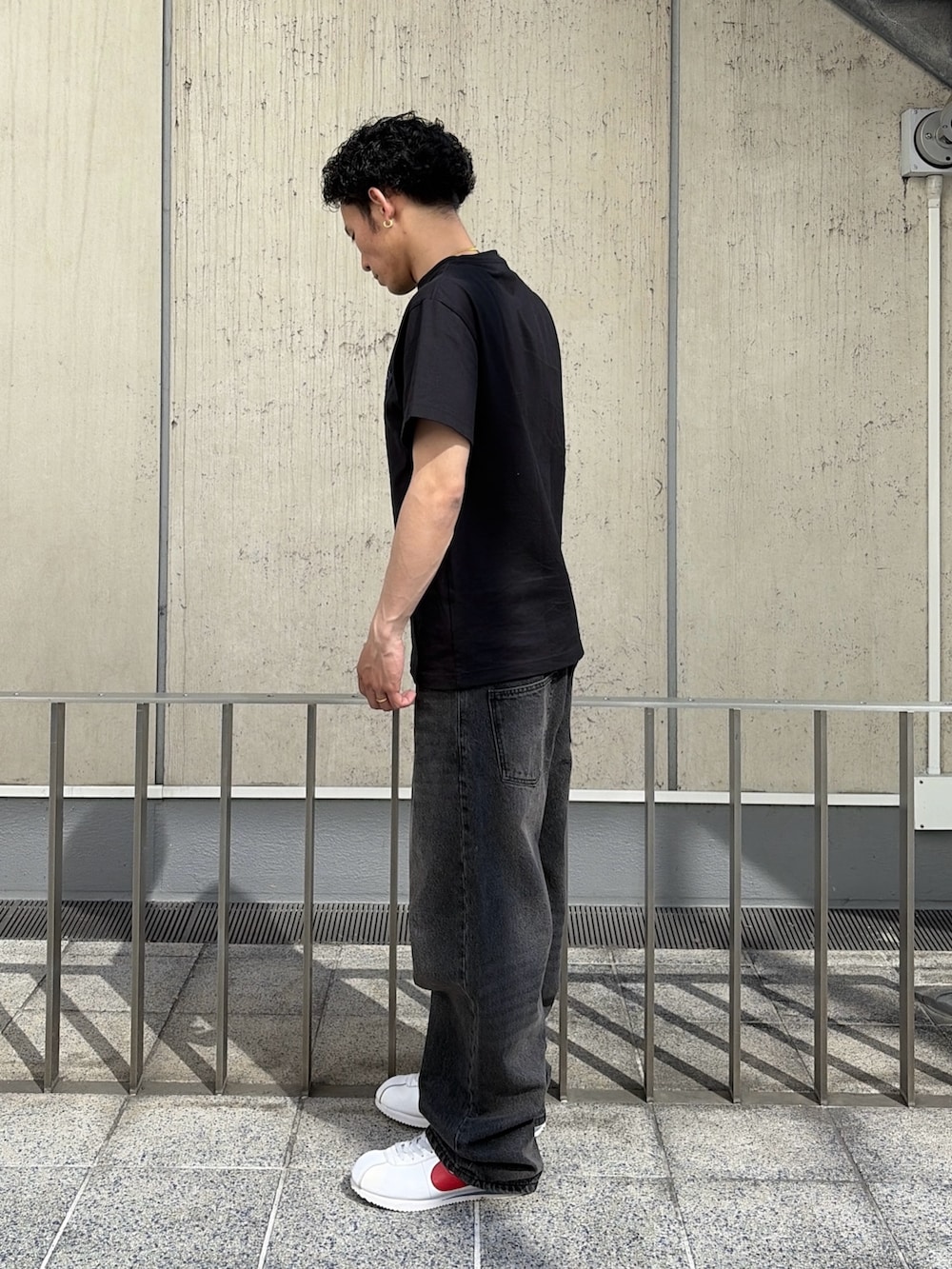 ブラック系のTシャツ/カットソー、ブルー系のデニムパンツを着用したメンズの春コーディネートの3枚目の写真