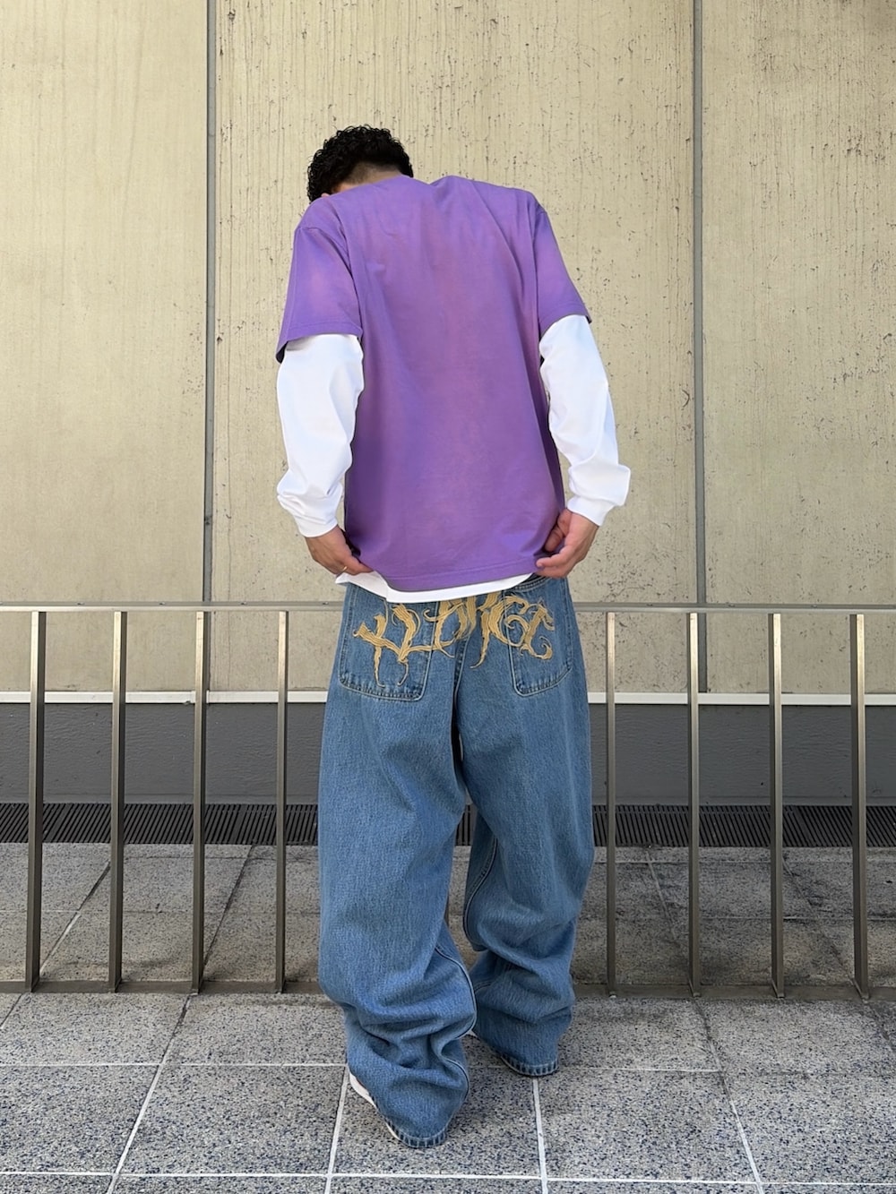 パープル系のTシャツ/カットソー、ホワイト系のTシャツ/カットソー、ブルー系のデニムパンツを着用したメンズの春コーディネートの4枚目の写真