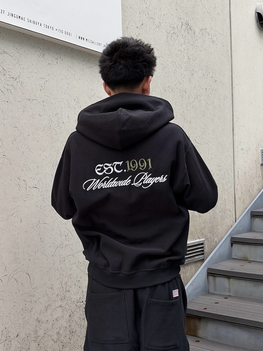 ブラック系のパーカー、ブラック系のスウェットパンツを着用したメンズの春コーディネートの8枚目の写真