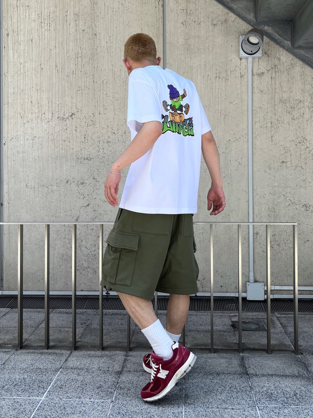 ホワイト系のTシャツ/カットソー、グリーン系のカーゴパンツを着用したメンズの春コーディネートの5枚目の写真