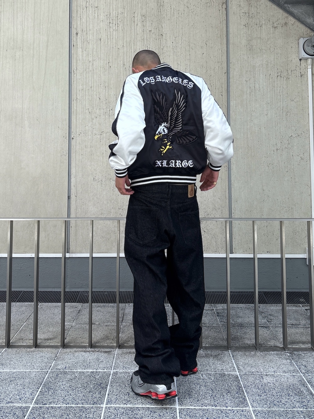 ブラック系のスカジャン、ブラック系のデニムパンツを着用したメンズの秋コーディネートの3枚目の写真