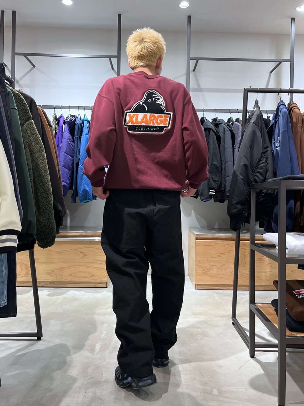 レッド系のスウェット、ブラック系のその他パンツ、ブラック系のダウンベストを着用したメンズの秋コーディネートの4枚目の写真