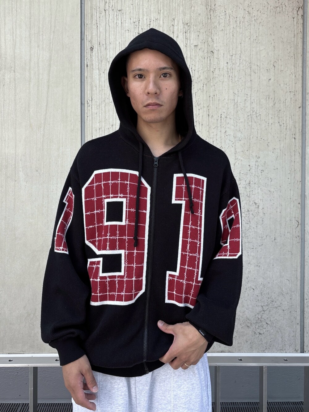 ブラック系のニット/セーター、グレー系のスウェットパンツを着用したメンズの秋コーディネートの5枚目の写真