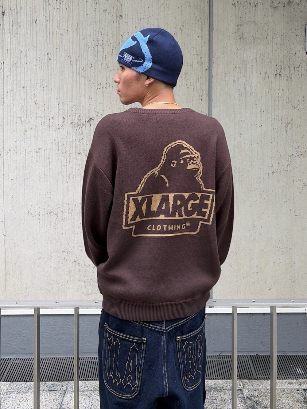 ブラウン系のニット/セーター、ブルー系のデニムパンツ、ブルー系のキャップを着用したメンズの秋コーディネートの9枚目の写真