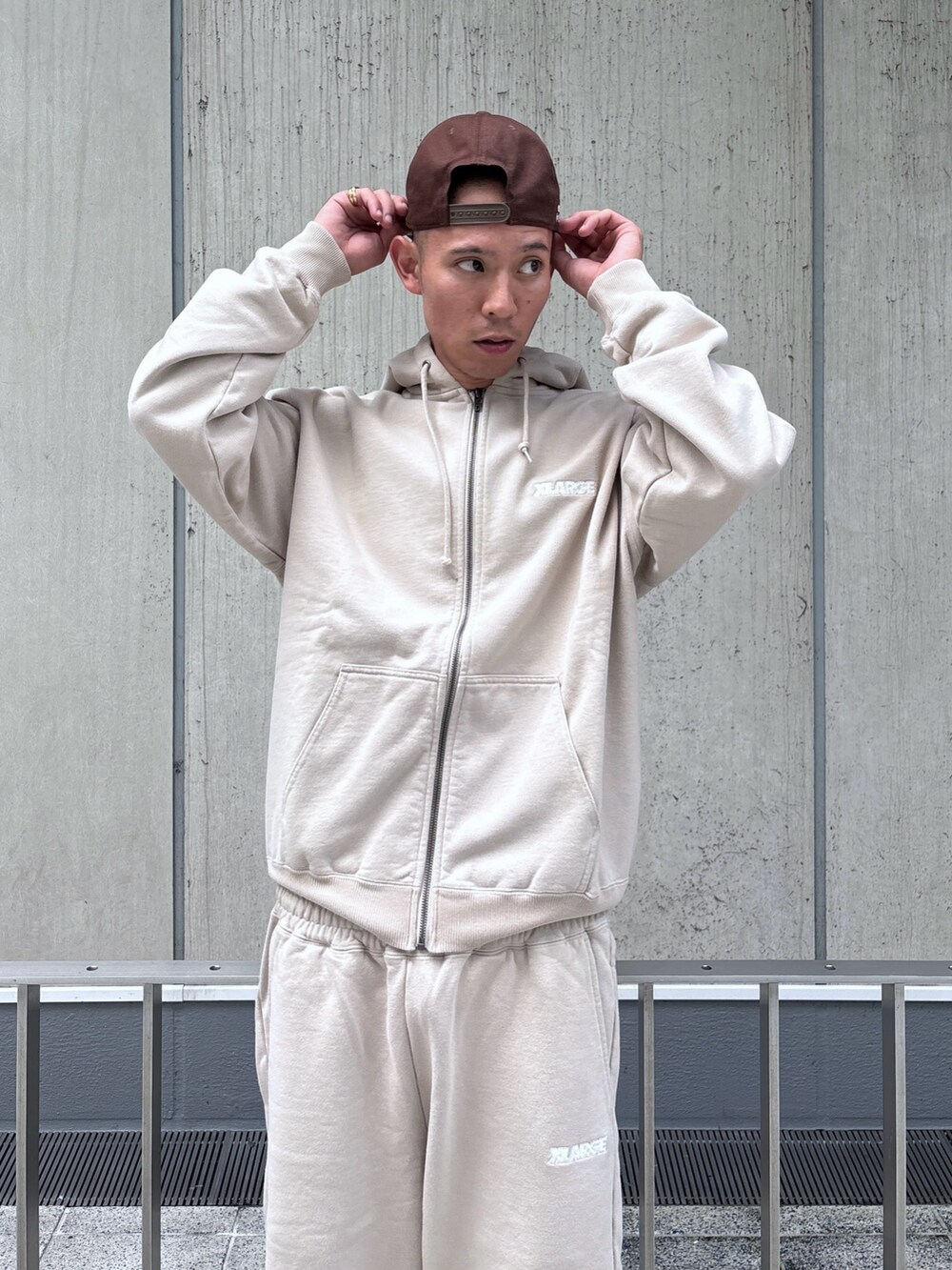 ベージュ系のスウェットパンツ、ベージュ系のパーカー、ブラウン系のキャップを着用したメンズの秋コーディネートの7枚目の写真