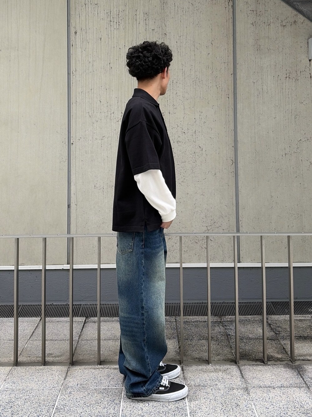 ホワイト系のTシャツ/カットソー、ブラック系のポロシャツ、ブルー系のデニムパンツを着用したメンズの春コーディネートの3枚目の写真