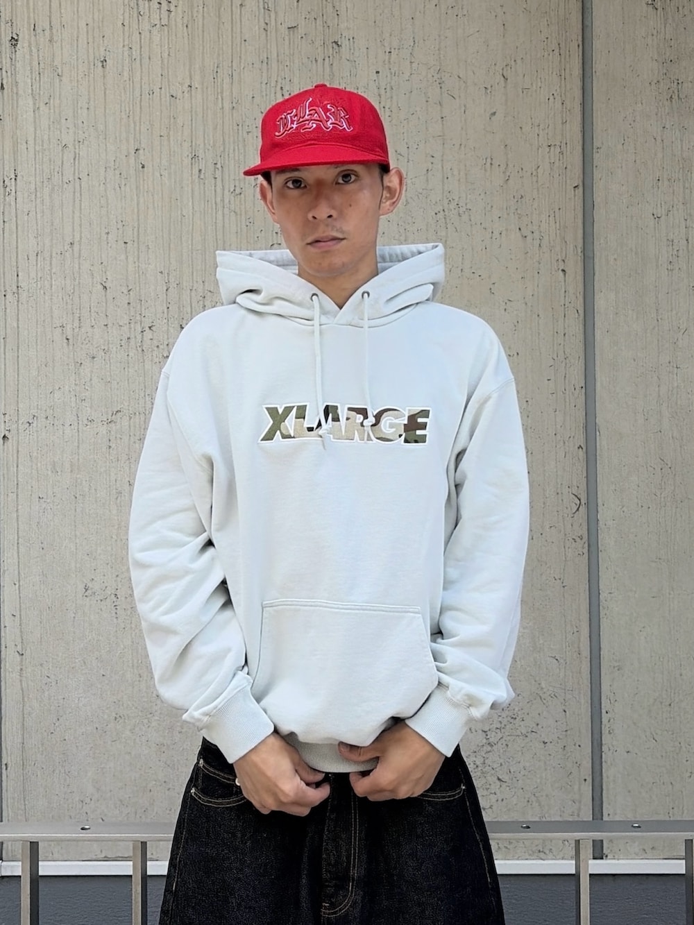 グレー系のパーカー、グリーン系のデニムパンツ、レッド系のキャップを着用したメンズの夏コーディネートの7枚目の写真