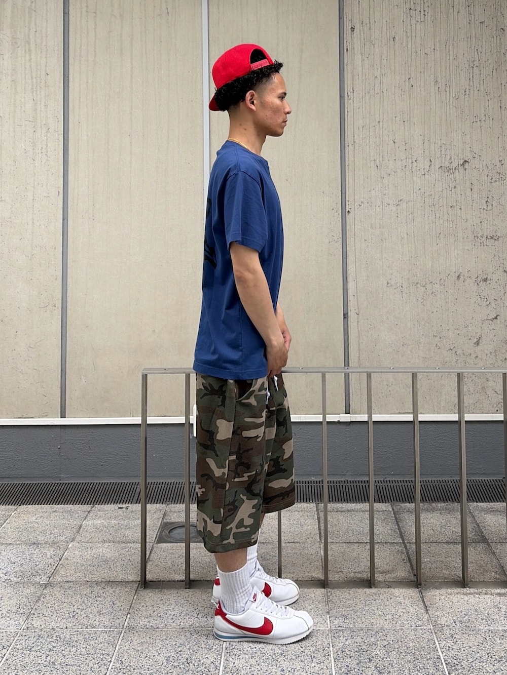 ブルー系のTシャツ/カットソー、その他のその他パンツ、レッド系のキャップを着用したメンズの春コーディネートの3枚目の写真