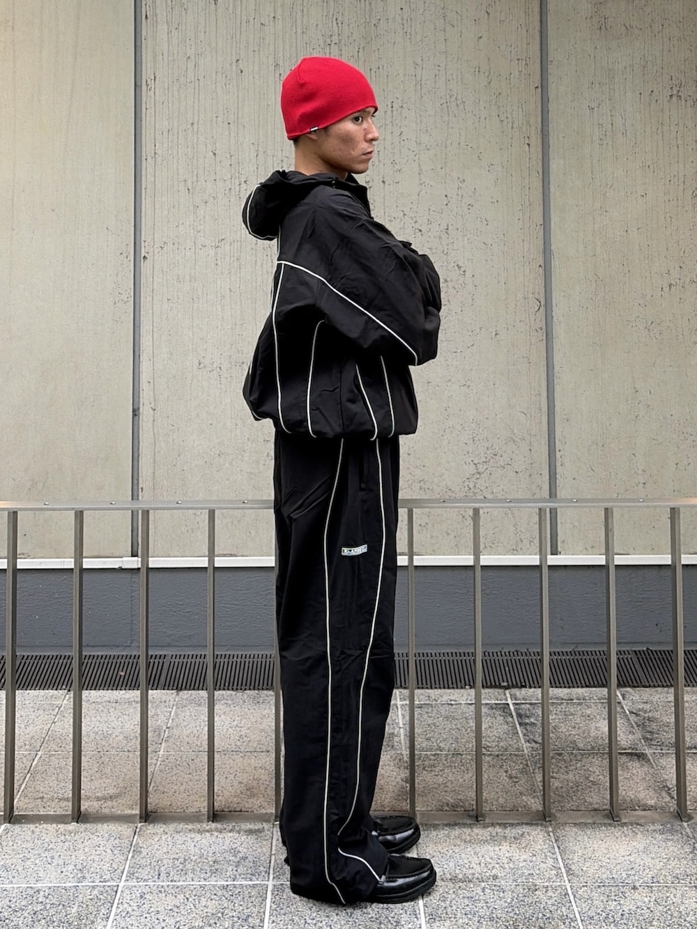 ブラック系のブルゾン、ブラック系のその他パンツ、レッド系のニットキャップ/ビーニーを着用したメンズの秋コーディネートの3枚目の写真