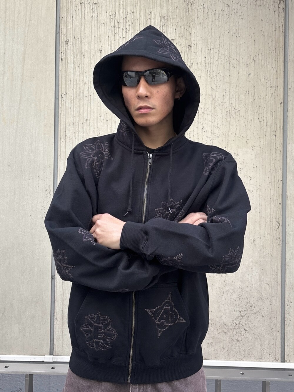 ブラック系のパーカー、ブラウン系のデニムパンツを着用したメンズの冬コーディネートの5枚目の写真