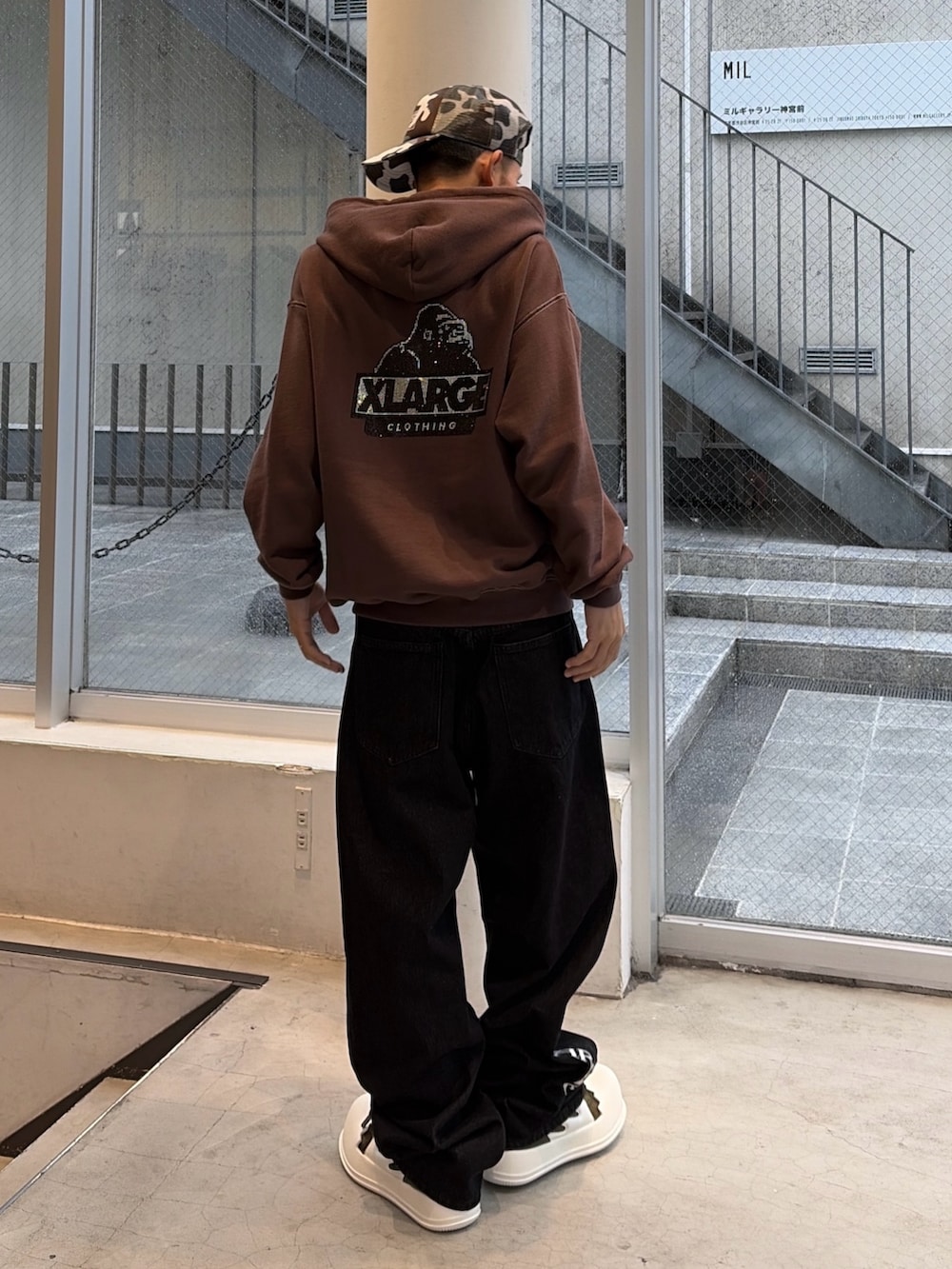 ブラウン系のパーカー、ブルー系のデニムパンツ、ブラック系のキャップを着用したメンズの秋コーディネートの4枚目の写真