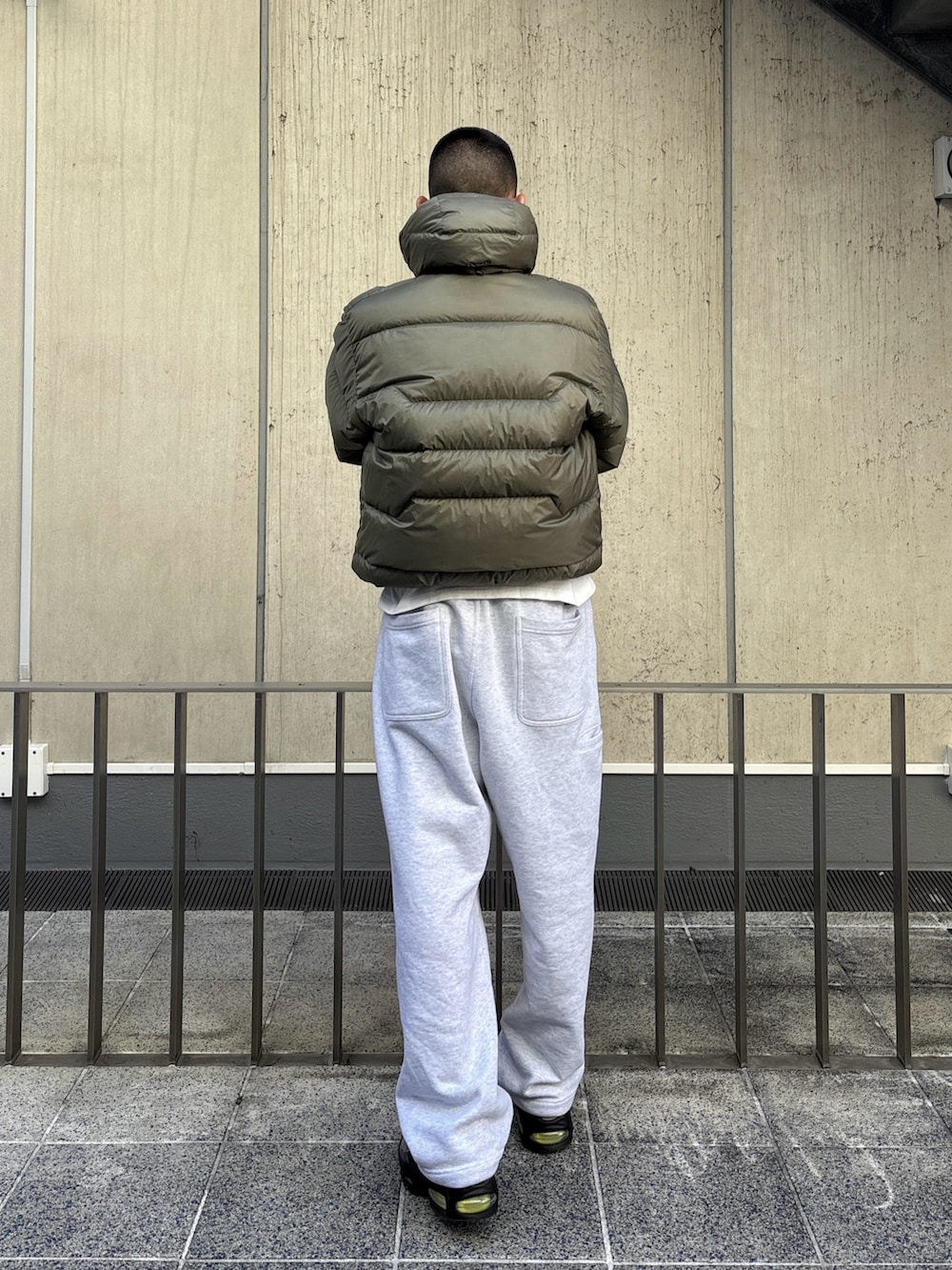 グリーン系のダウンジャケット/コート、グレー系のスウェットパンツを着用したメンズの冬コーディネートの7枚目の写真