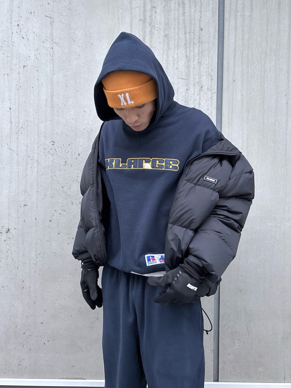 ブラック系のダウンジャケット/コート、ブルー系のパーカー、ブルー系のスウェットパンツを着用したメンズの秋コーディネートの7枚目の写真