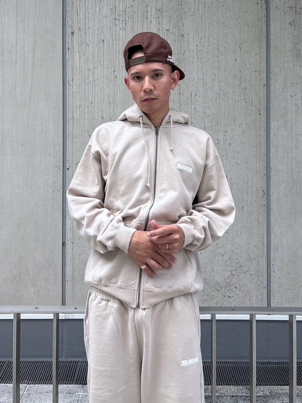 ベージュ系のスウェットパンツ、ベージュ系のパーカー、ブラウン系のキャップを着用したメンズの秋コーディネートの6枚目の写真