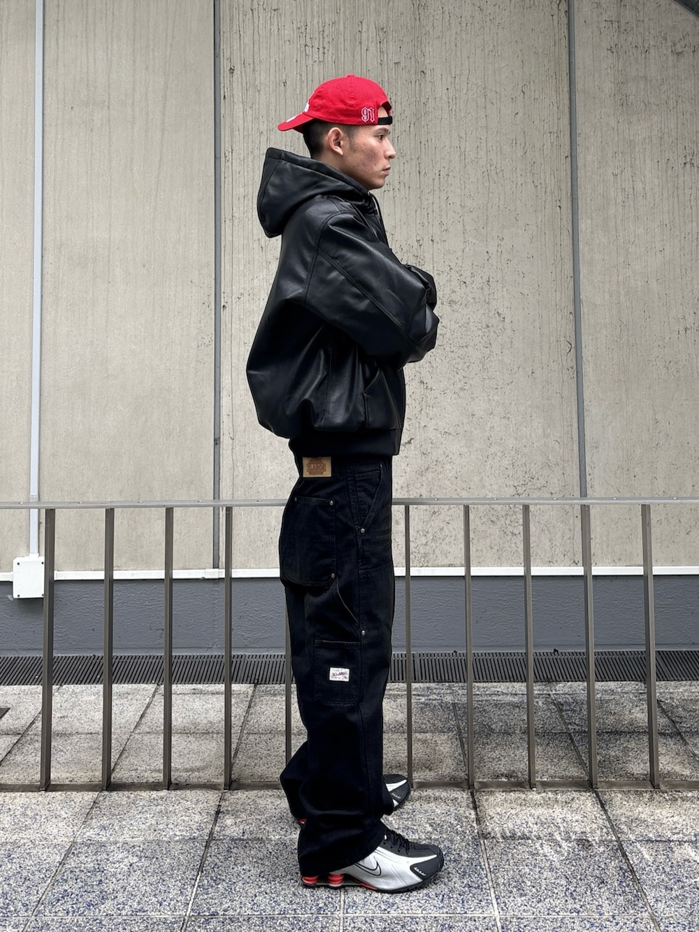 ブラック系のその他アウター、ブラウン系のその他パンツ、レッド系のキャップを着用したメンズの冬コーディネートの3枚目の写真