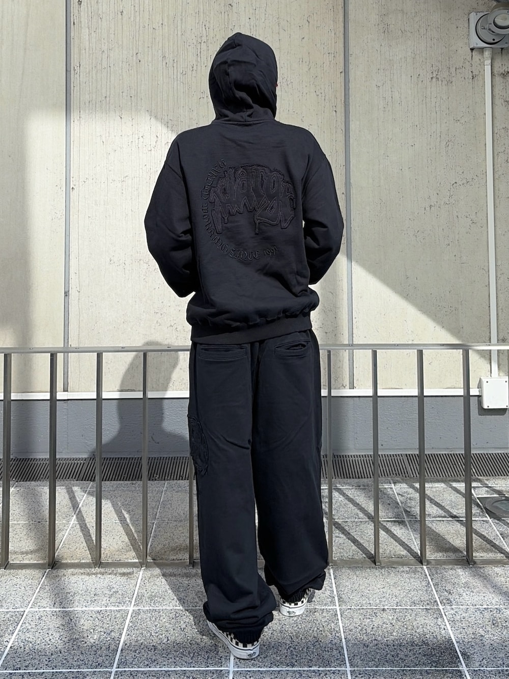 ブラック系のパーカー、ブラック系のその他パンツ、レッド系のキャップを着用したメンズの夏コーディネートの6枚目の写真