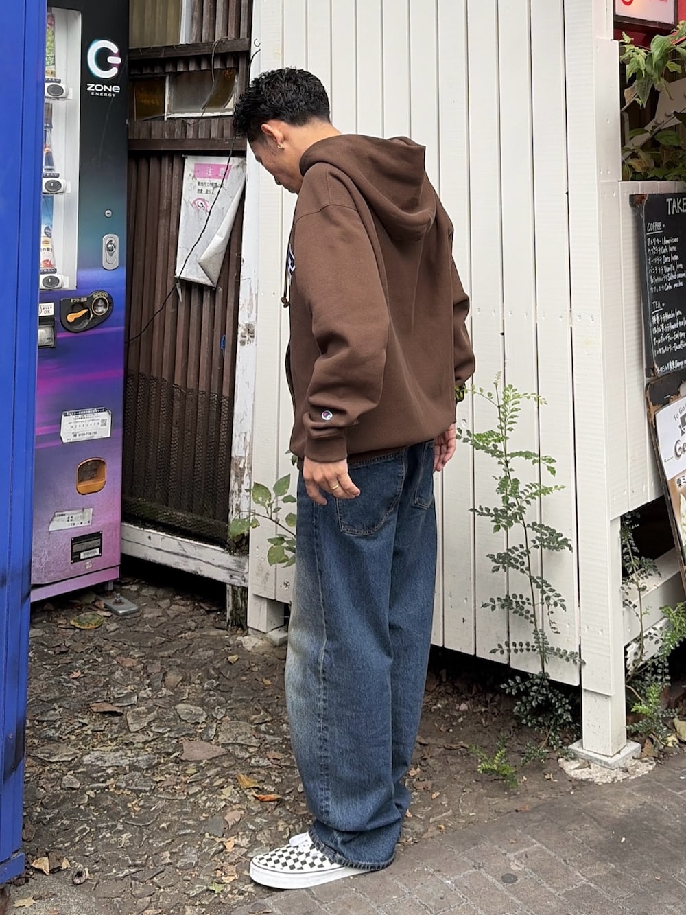 グレー系のパーカー、ブルー系のデニムパンツを着用したメンズの秋コーディネートの3枚目の写真