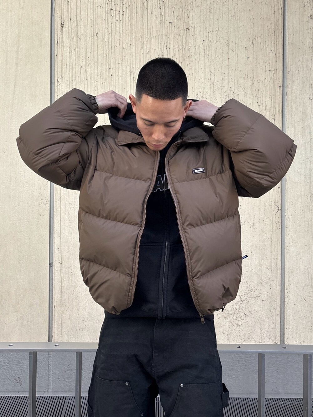 ブラック系のダウンジャケット/コート、ブラウン系のその他パンツを着用したメンズの冬コーディネートの6枚目の写真