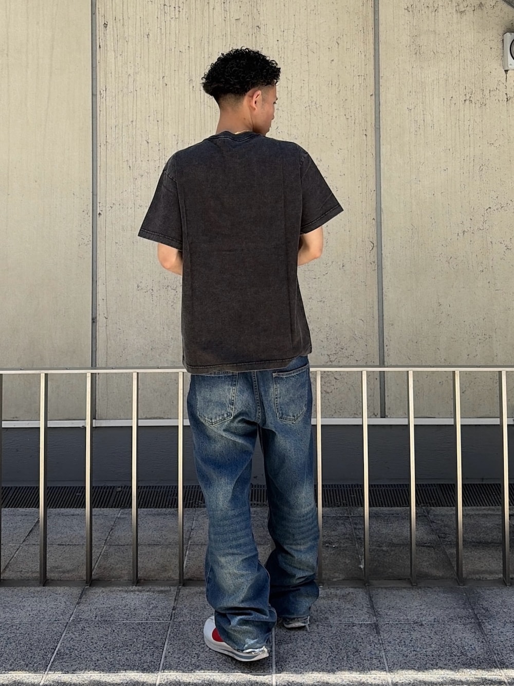ブラック系のTシャツ/カットソー、ブルー系のデニムパンツを着用したメンズの夏コーディネートの4枚目の写真