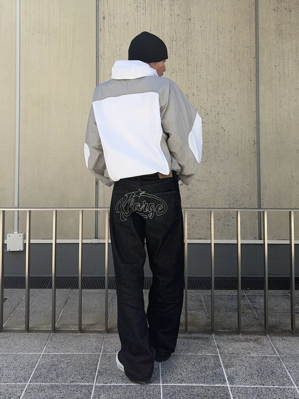 ブルー系のナイロンジャケット、ブラック系のデニムパンツ、ピンク系のニットキャップ/ビーニーを着用したメンズの春コーディネートの5枚目の写真