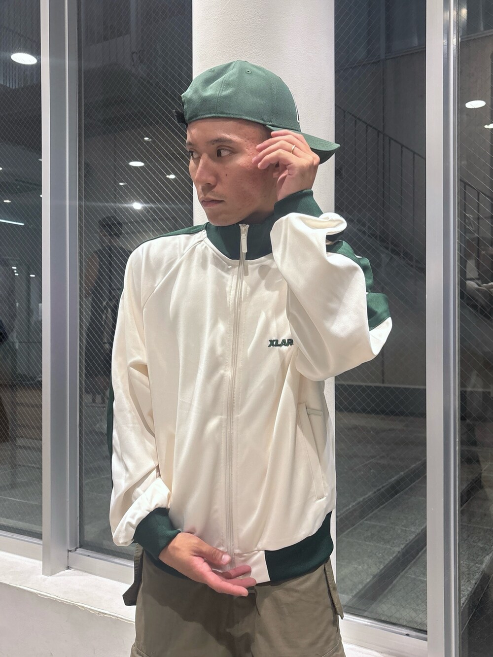 ホワイト系のブルゾン、グリーン系のカーゴパンツ、グリーン系のキャップを着用したメンズの秋コーディネートの6枚目の写真