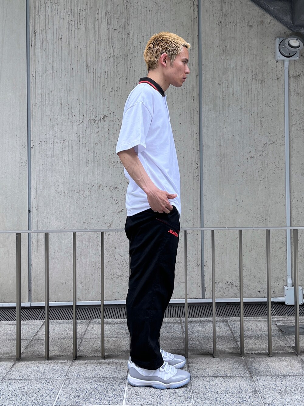 ブラック系のポロシャツ、グリーン系のその他パンツを着用したメンズの春コーディネートの3枚目の写真