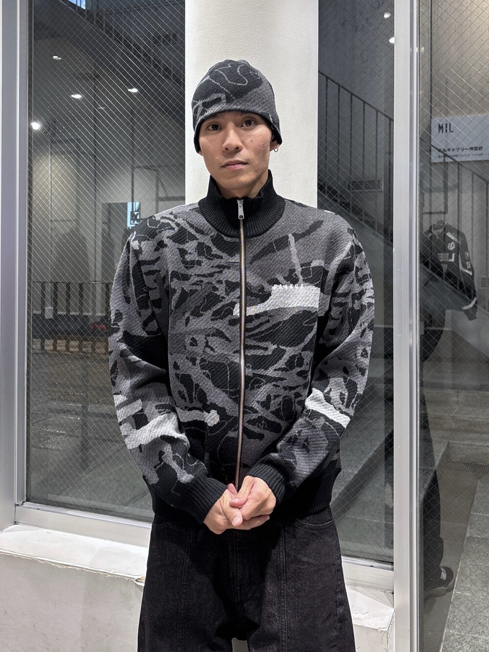 ブラック系のニット/セーター、ブラック系のデニムパンツ、ブラック系のニットキャップ/ビーニーを着用したメンズの秋コーディネートの5枚目の写真