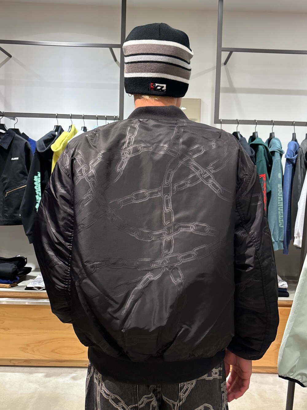 ブラック系のデニムパンツ、ブラック系のブルゾン、ブラック系のニットキャップ/ビーニーを着用したメンズの春コーディネートの6枚目の写真