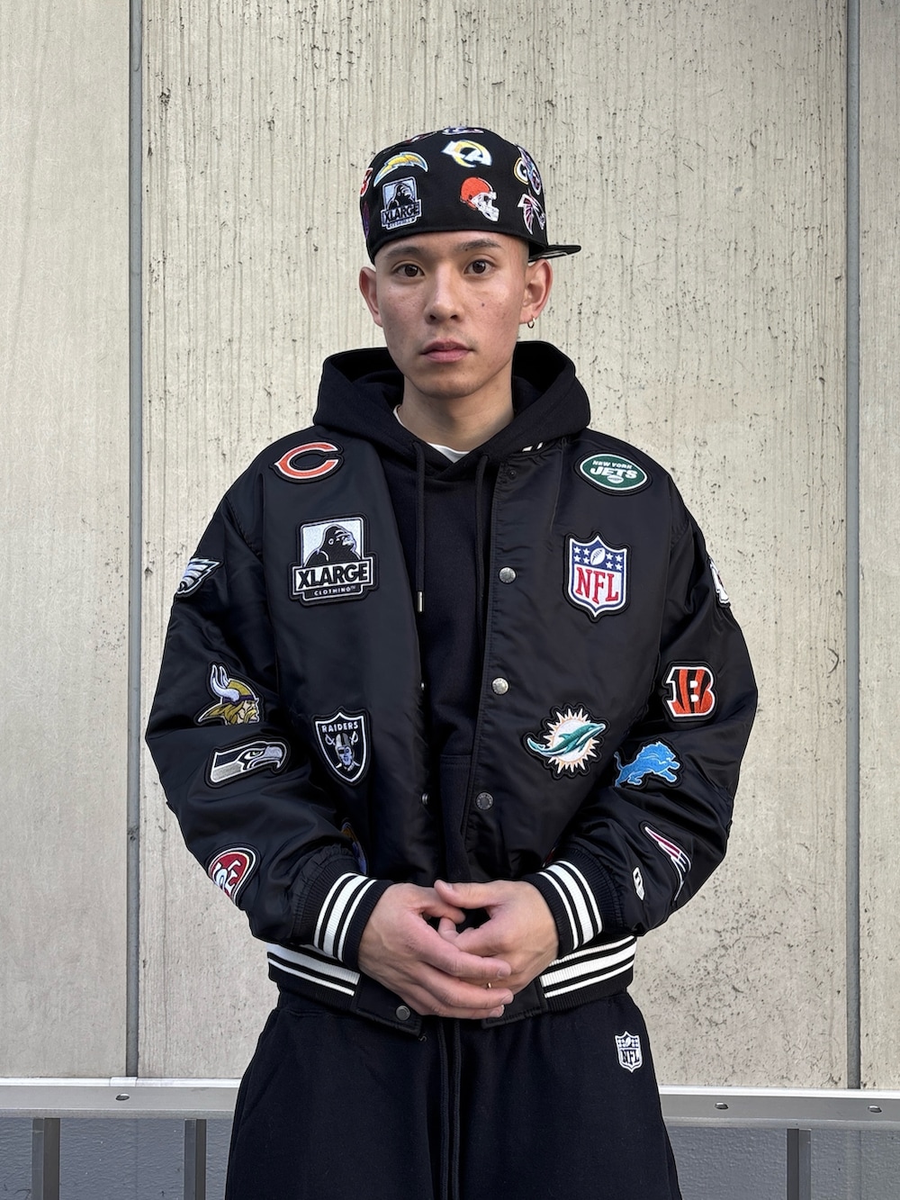 ブラック系のブルゾン、ブラック系のパーカー、ブラック系のスウェットパンツを着用したメンズの冬コーディネートの5枚目の写真