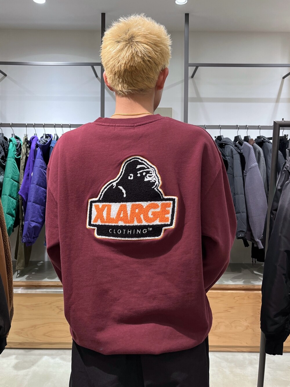 レッド系のスウェット、ブラック系のその他パンツ、ブラック系のダウンベストを着用したメンズの秋コーディネートの6枚目の写真