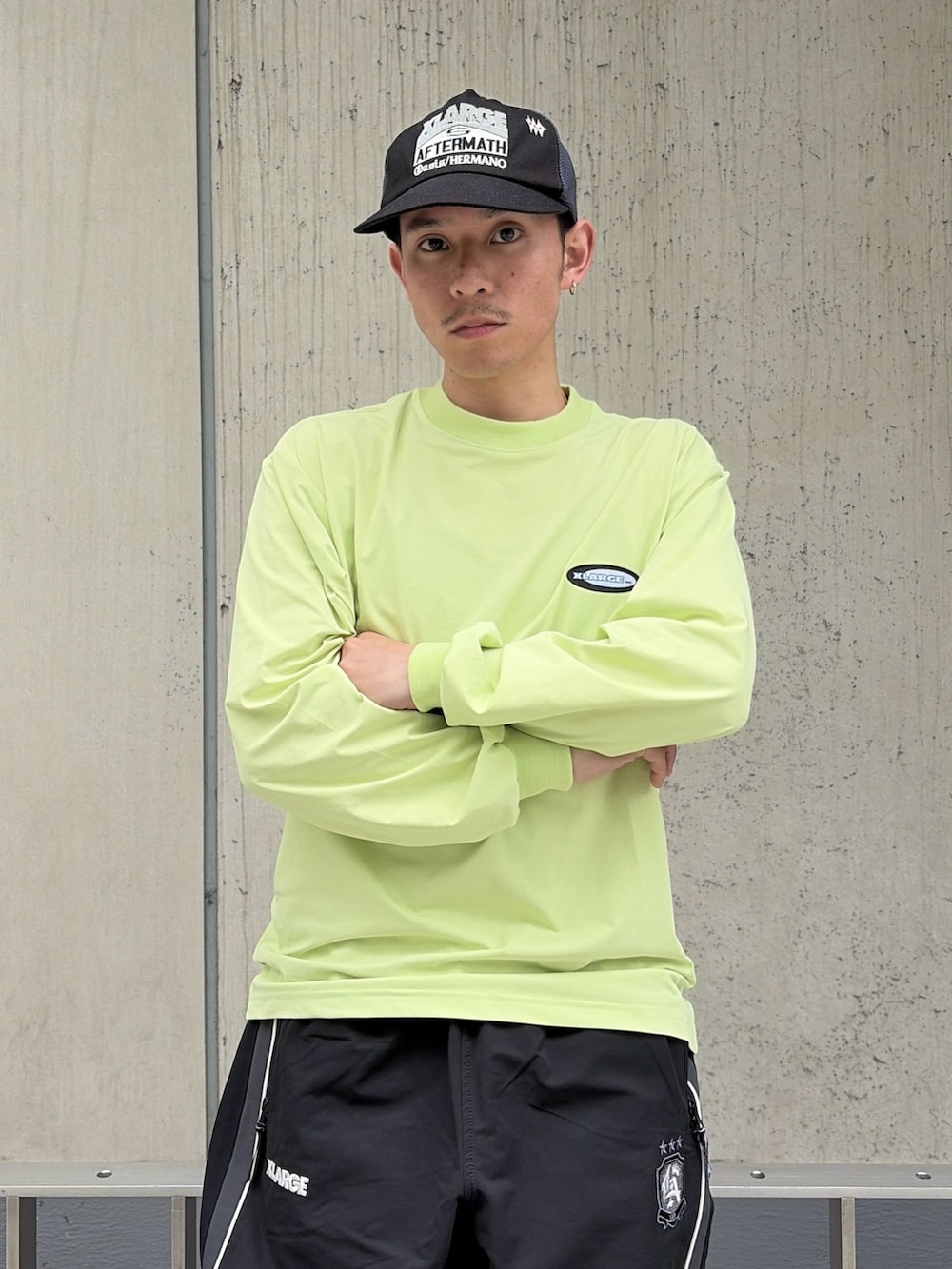 グリーン系のTシャツ/カットソー、ブラック系のその他パンツ、ブラック系のキャップを着用したメンズの春コーディネートの6枚目の写真