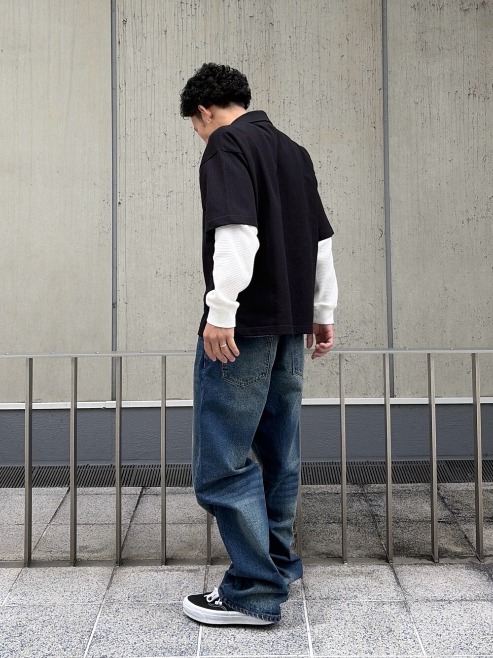 ホワイト系のTシャツ/カットソー、ブラック系のポロシャツ、ブルー系のデニムパンツを着用したメンズの春コーディネートの4枚目の写真