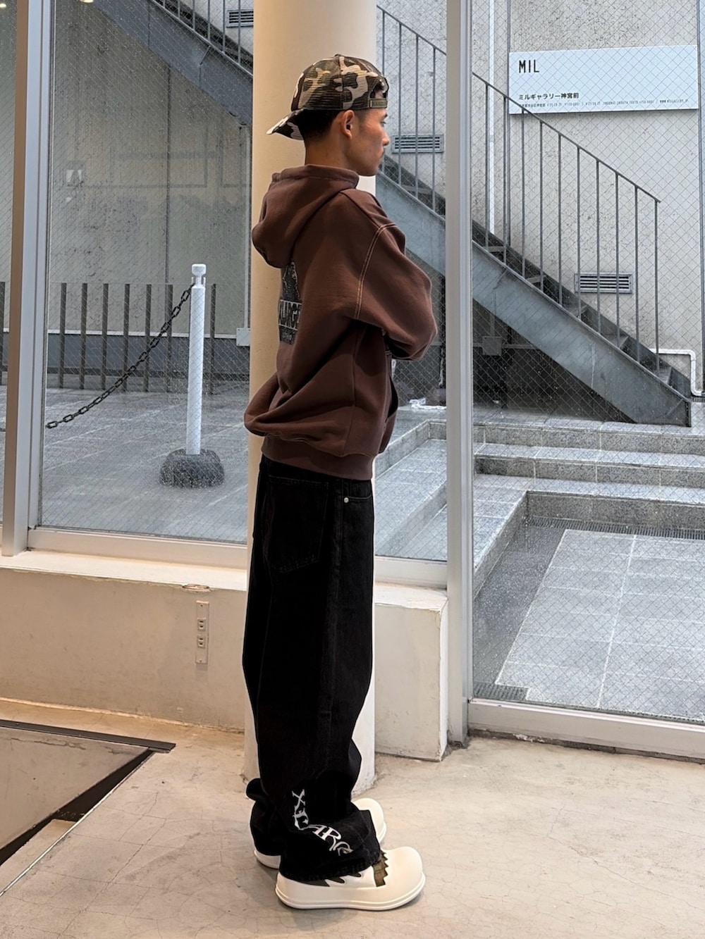 ブラウン系のパーカー、ブルー系のデニムパンツ、ブラック系のキャップを着用したメンズの秋コーディネートの5枚目の写真