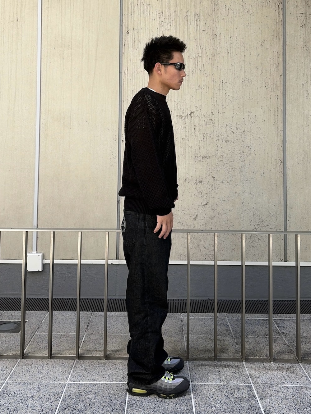 ブラック系のニット/セーター、ブラック系のデニムパンツを着用したメンズの春コーディネートの3枚目の写真