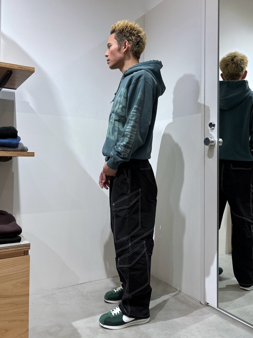 ブラック系のカーゴパンツ、グリーン系のパーカーを着用したメンズの冬コーディネートの2枚目の写真