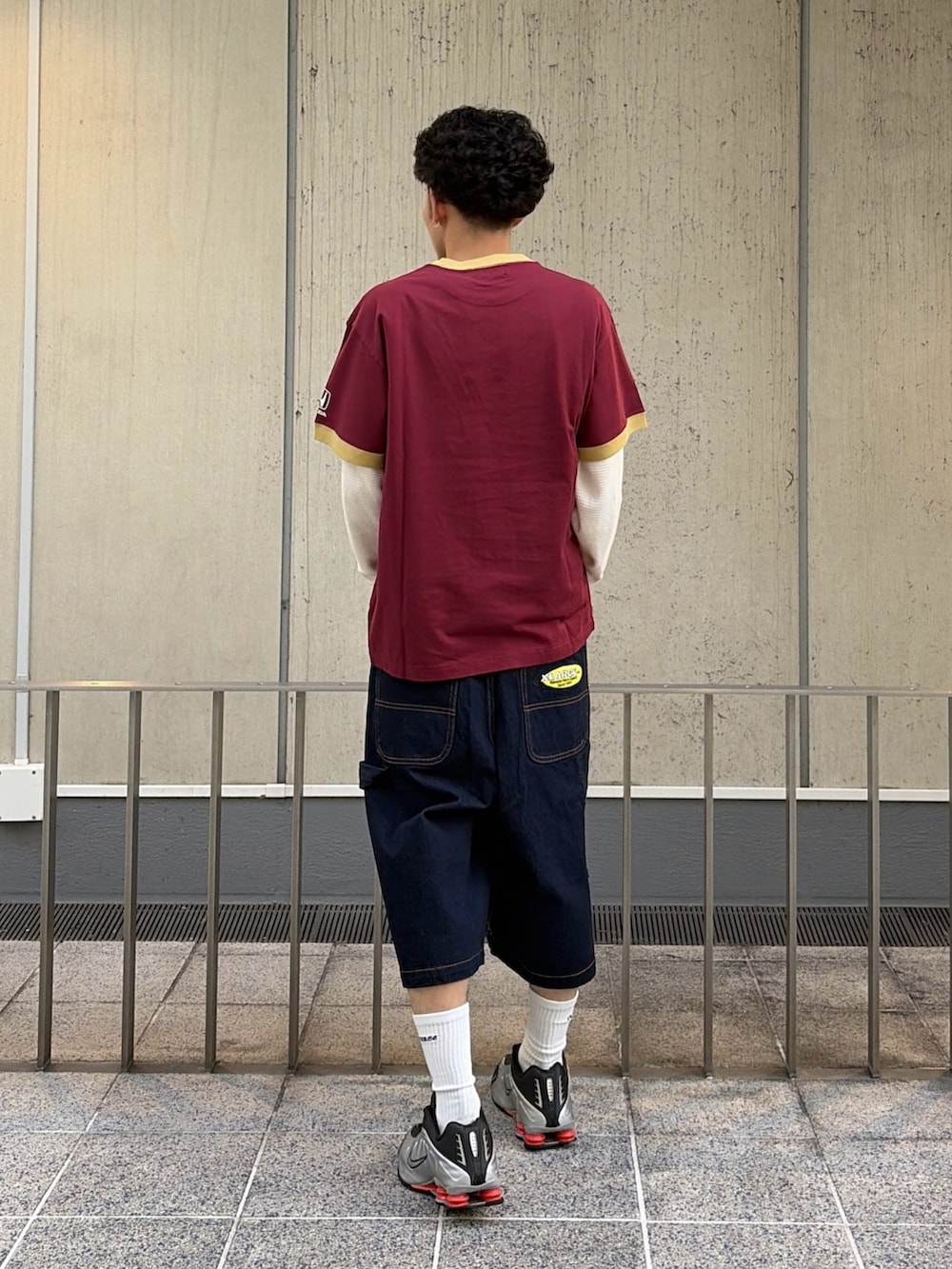 レッド系のTシャツ/カットソー、ブルー系のデニムパンツ、ホワイト系のTシャツ/カットソーを着用したメンズの春コーディネートの4枚目の写真
