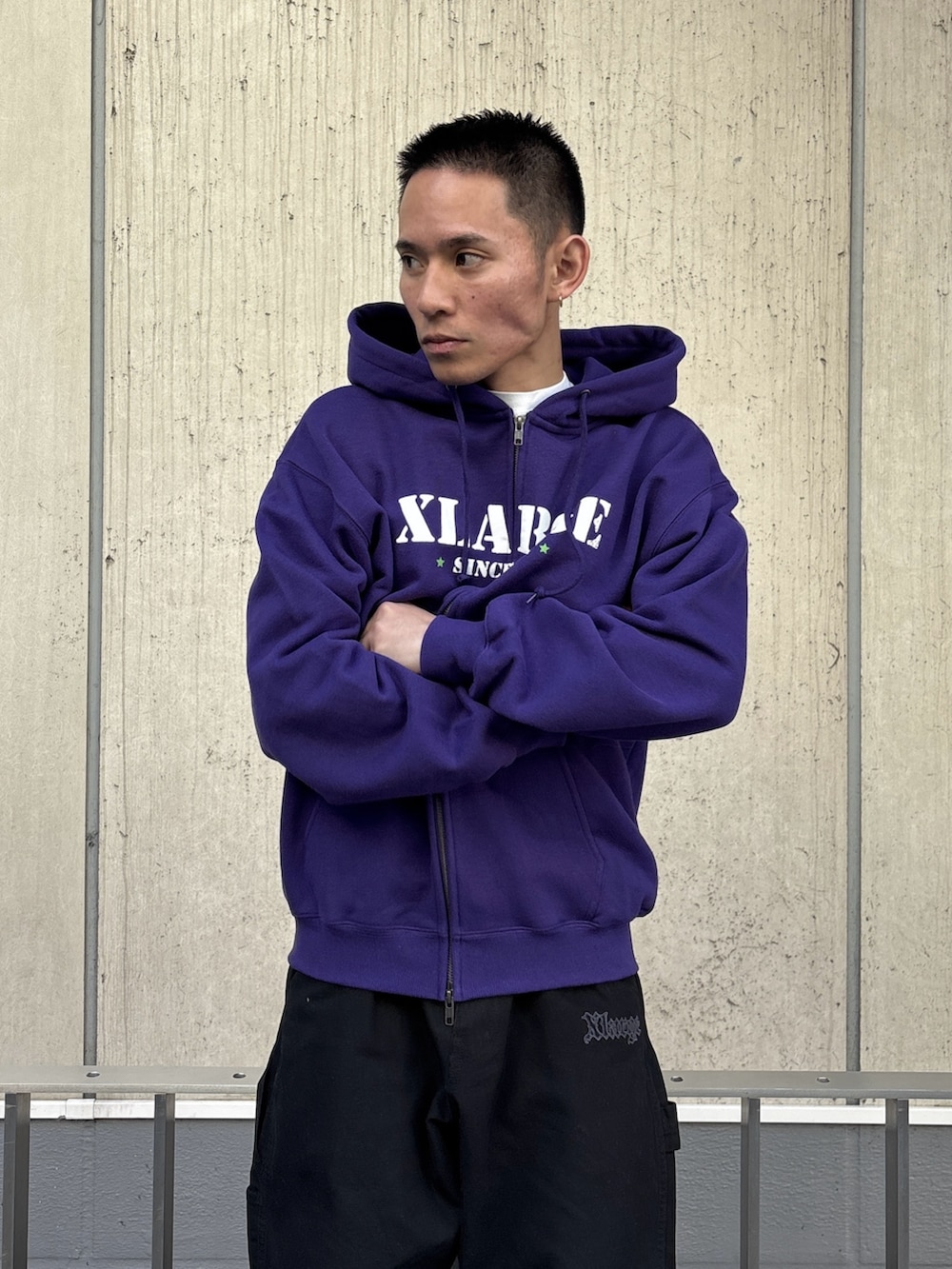 パープル系のパーカー、ブラック系のその他パンツを着用したメンズの冬コーディネートの6枚目の写真