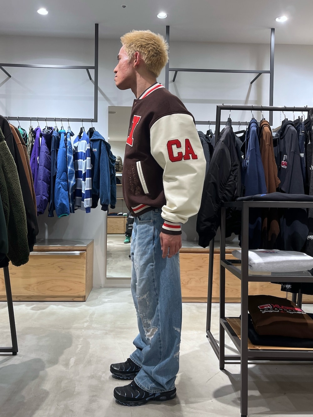 ブラウン系のスタジャン、ブルー系のデニムパンツを着用したメンズの秋コーディネートの3枚目の写真