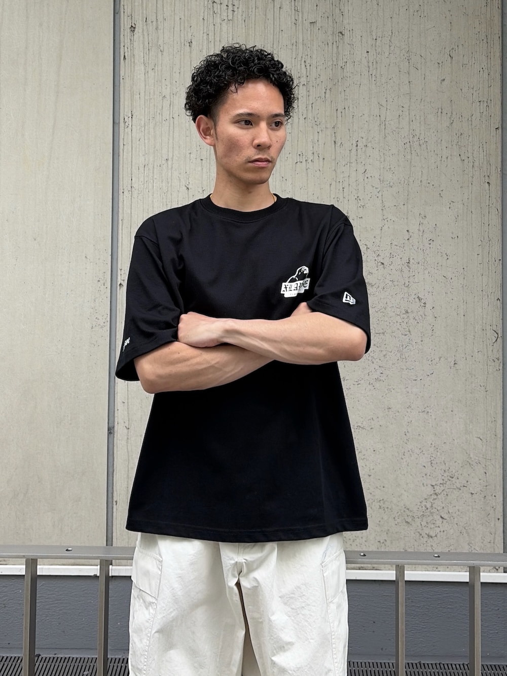ブラック系のTシャツ/カットソー、ホワイト系のカーゴパンツを着用したメンズの夏コーディネートの5枚目の写真