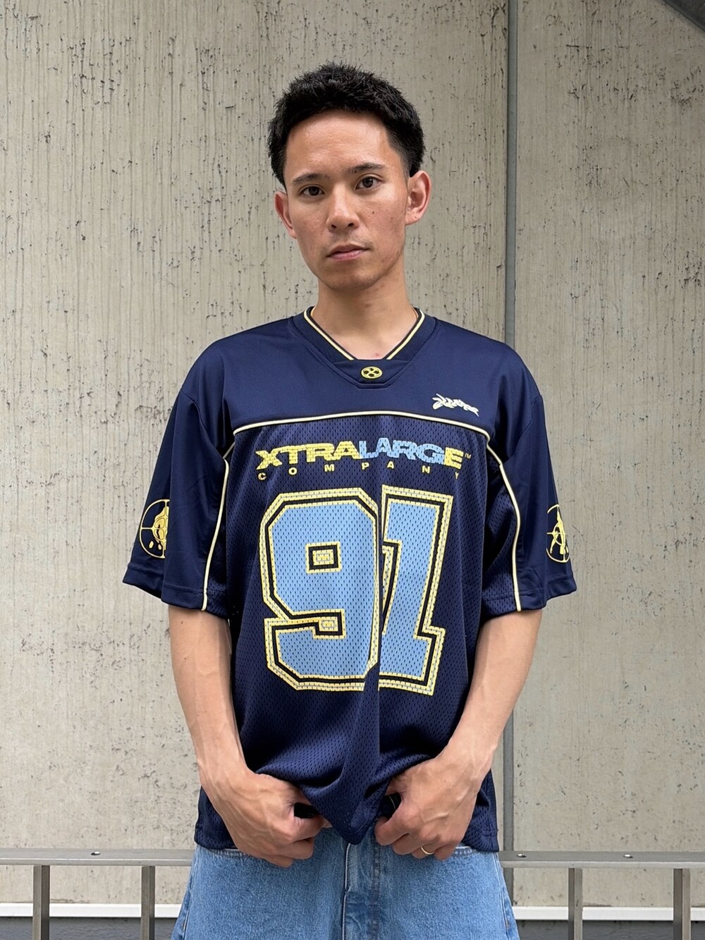 ホワイト系のTシャツ/カットソー、ブルー系のデニムパンツを着用したメンズの夏コーディネートの5枚目の写真