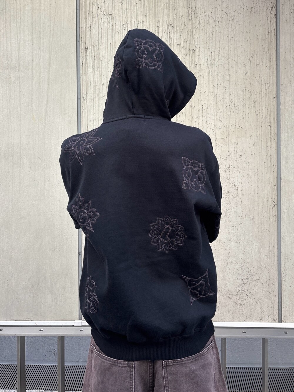 ブラック系のパーカー、ブラウン系のデニムパンツを着用したメンズの冬コーディネートの6枚目の写真