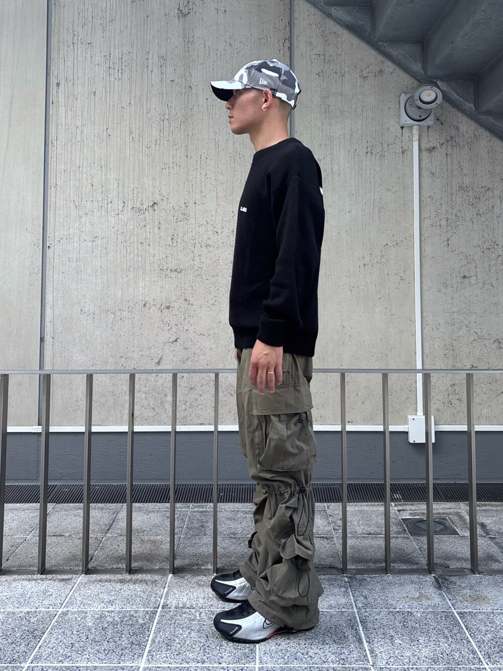 ブラック系のニット/セーター、グリーン系のカーゴパンツ、その他のキャップを着用したメンズの秋コーディネートの3枚目の写真